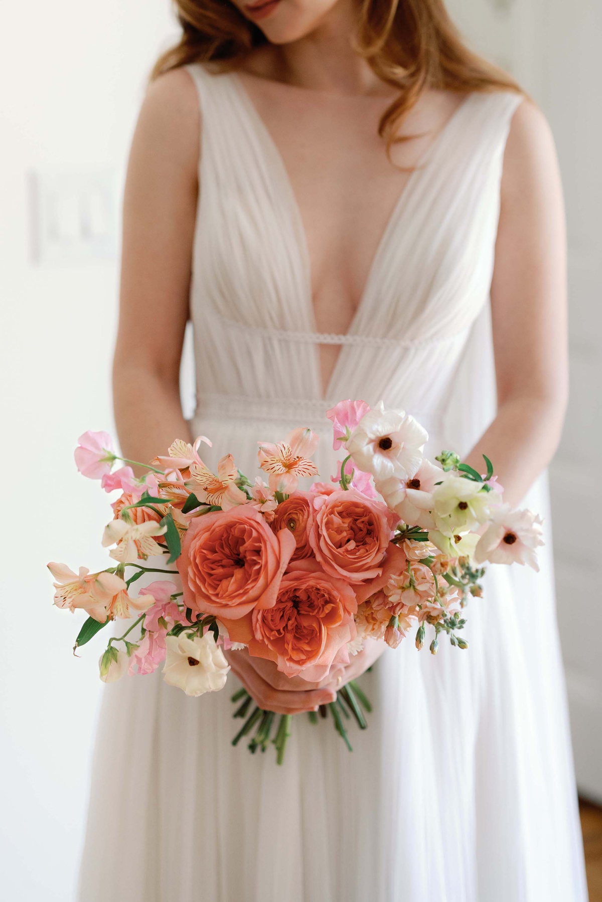 Bride holding a peach and pink wedding bouquet