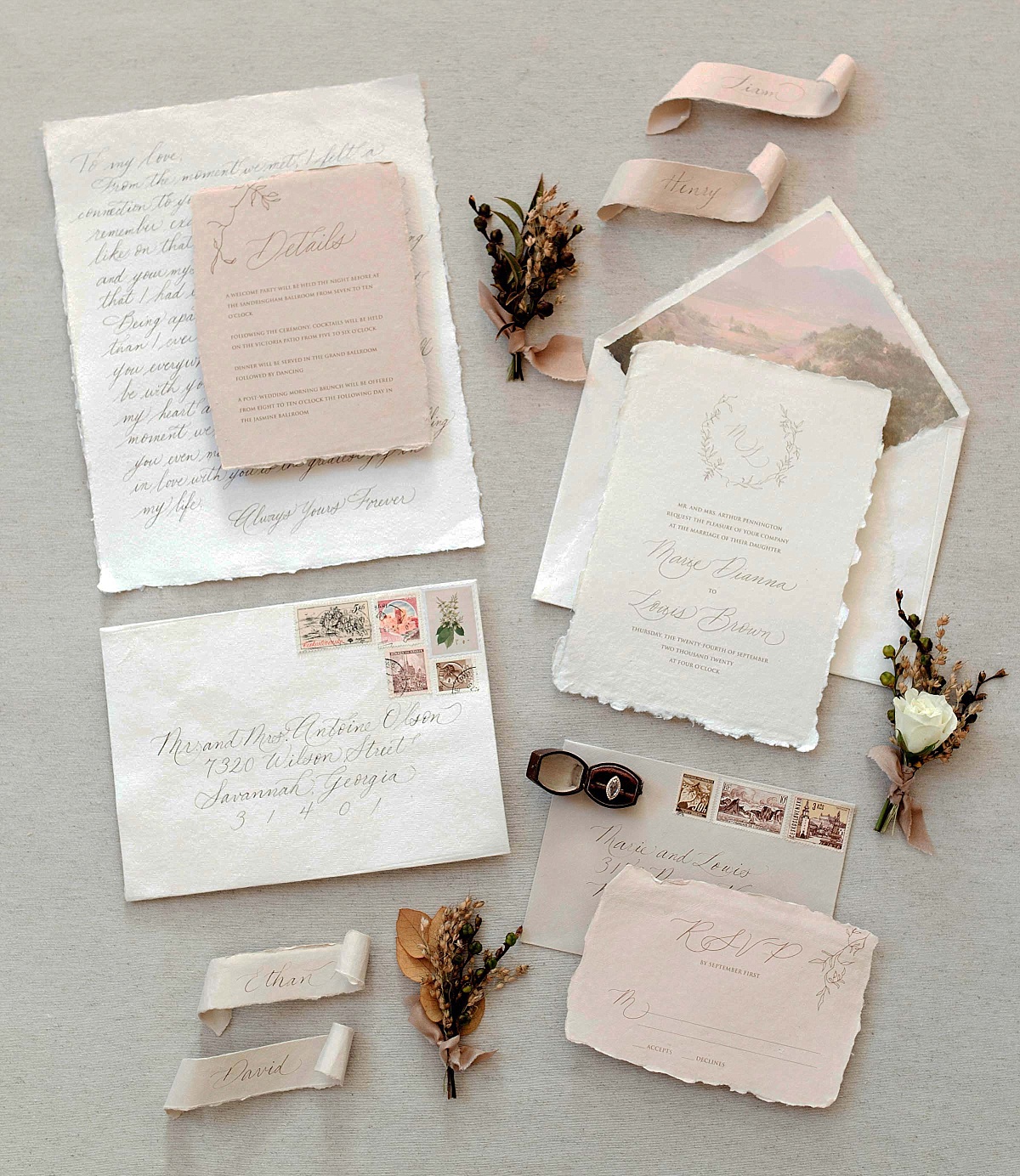 A flatlay of detailed wedding envelopes and a wedding invitation suite