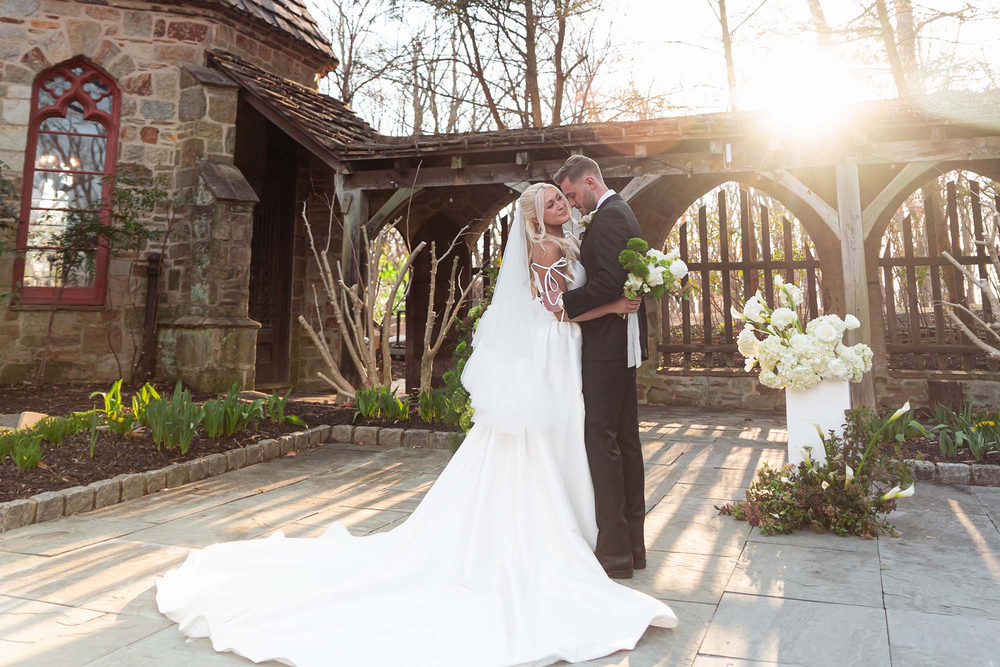 Bride and groom walking hand in hand outside a romantic stone castle on their wedding day.