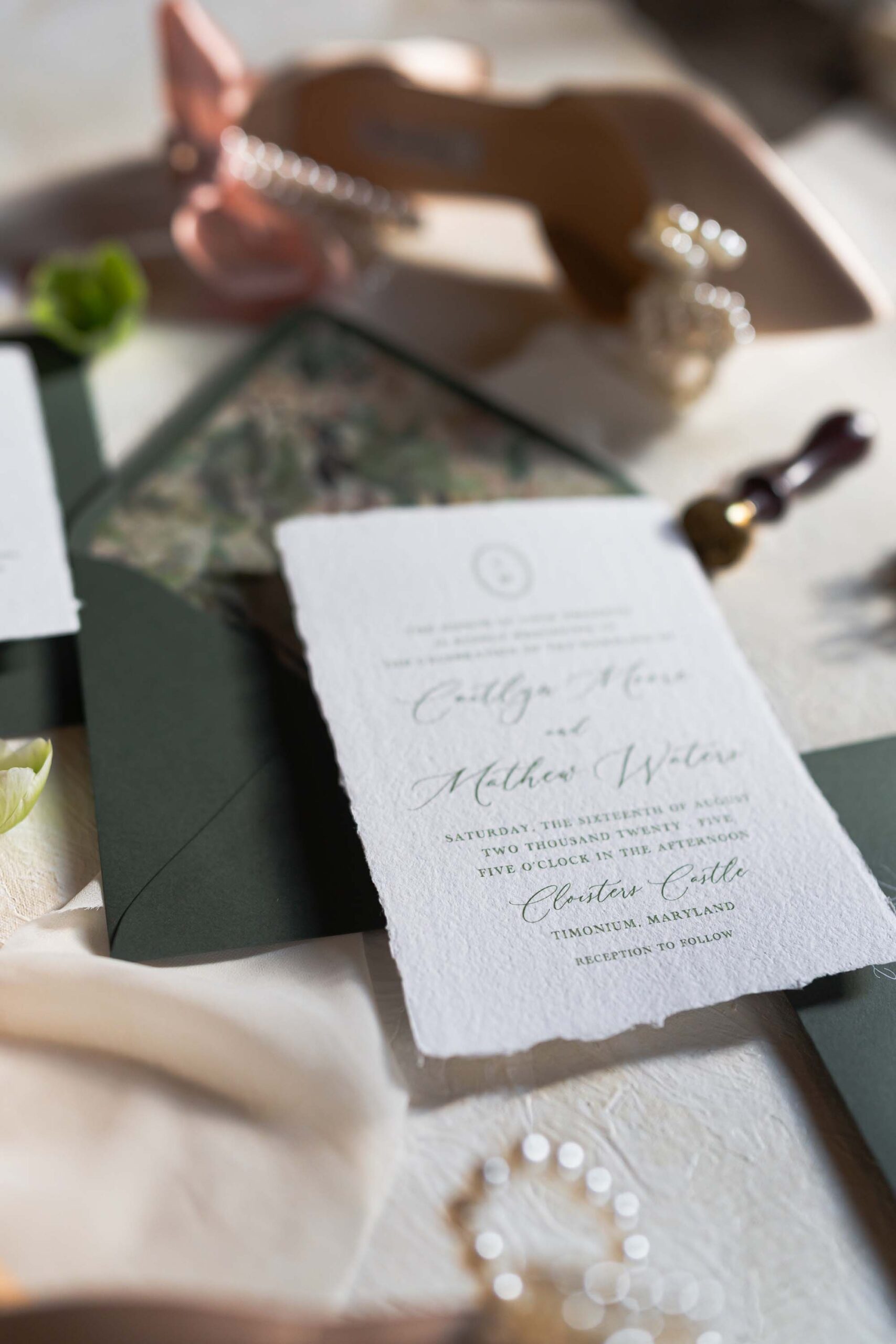 Flatlay of a green floral wedding invitation suite 