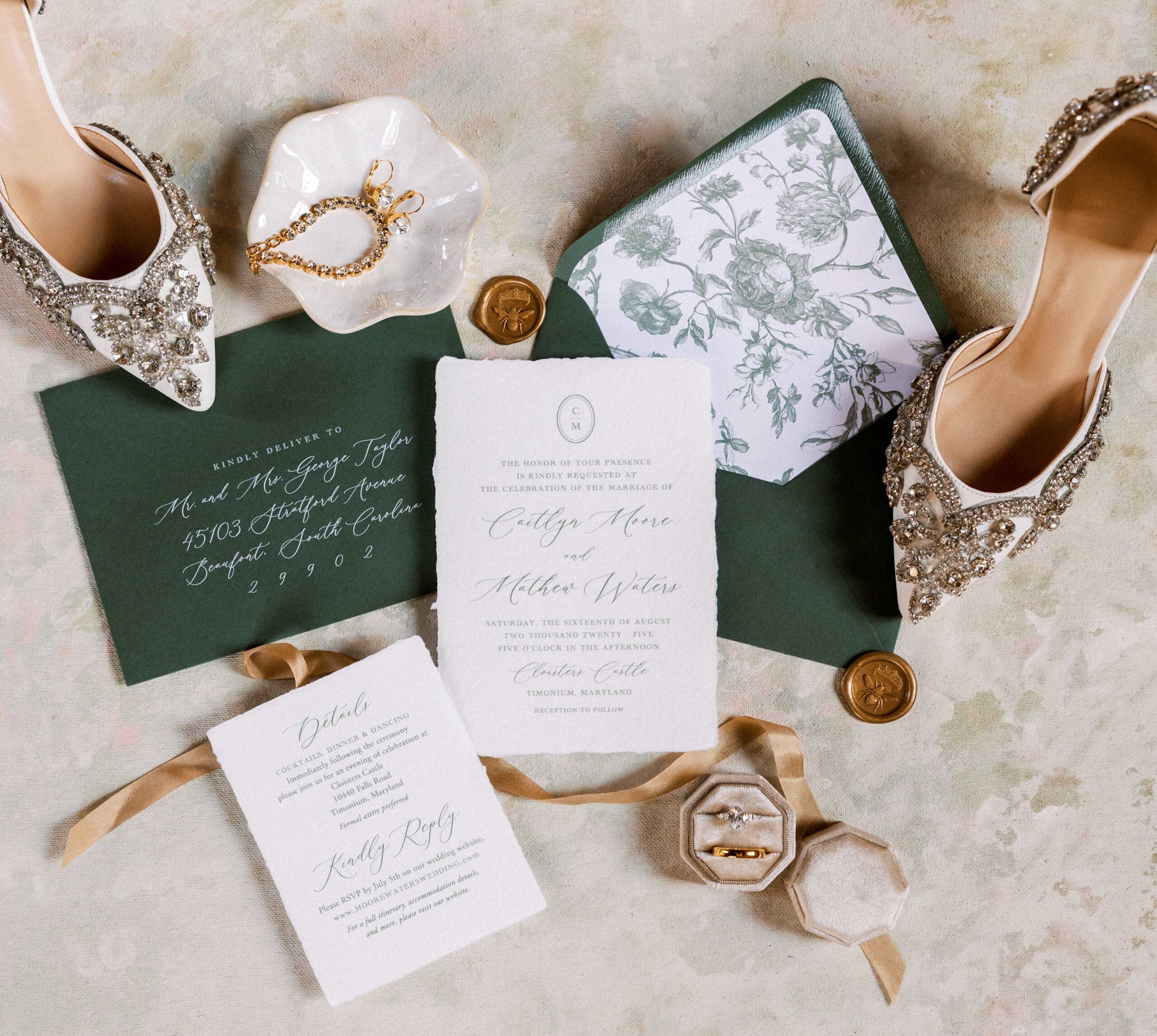 Flatlay of a green floral wedding invitation suite
