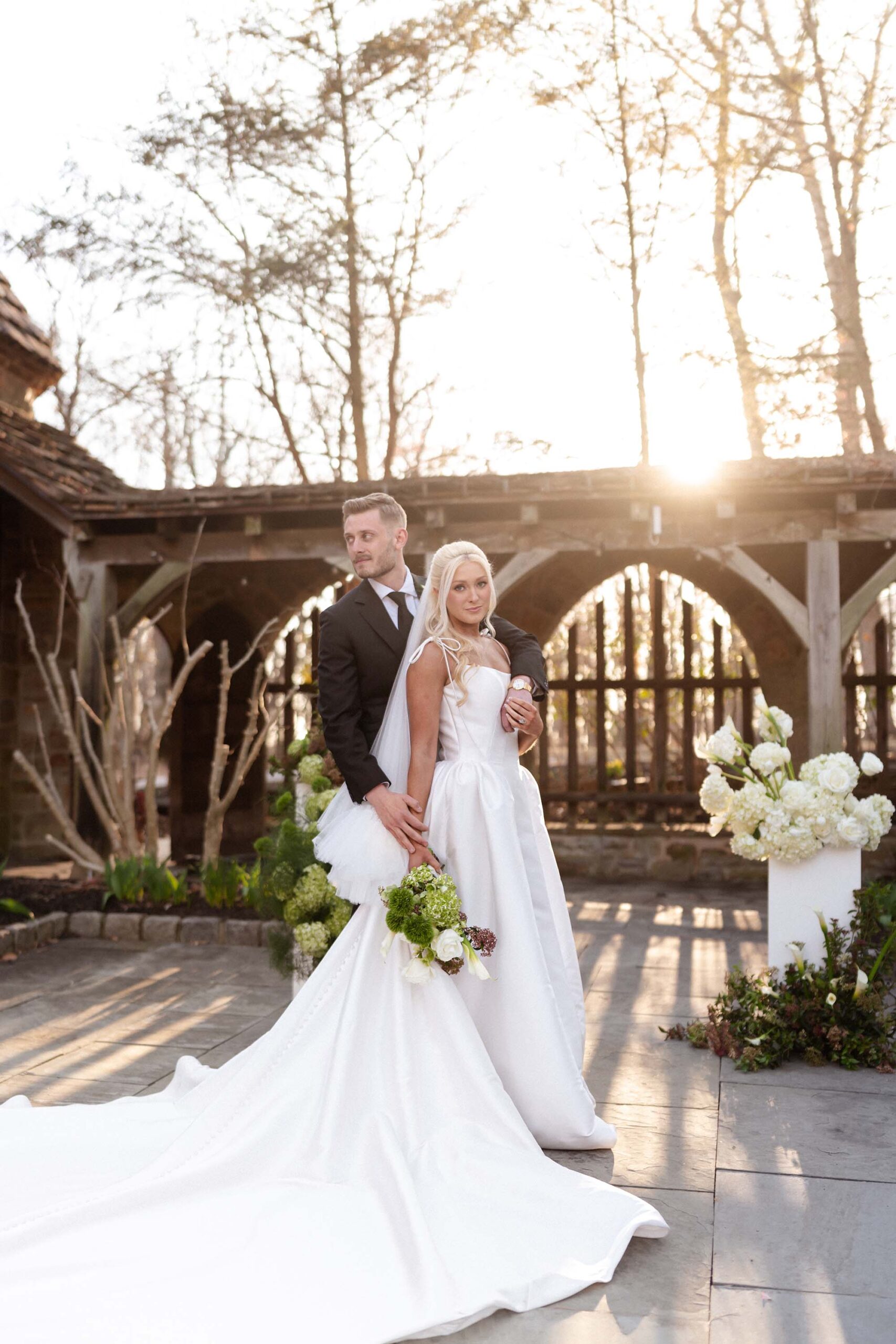 Bride and groom in sunset courtyard with train and florals at The Cloisters Castle wedding venue in Maryland
