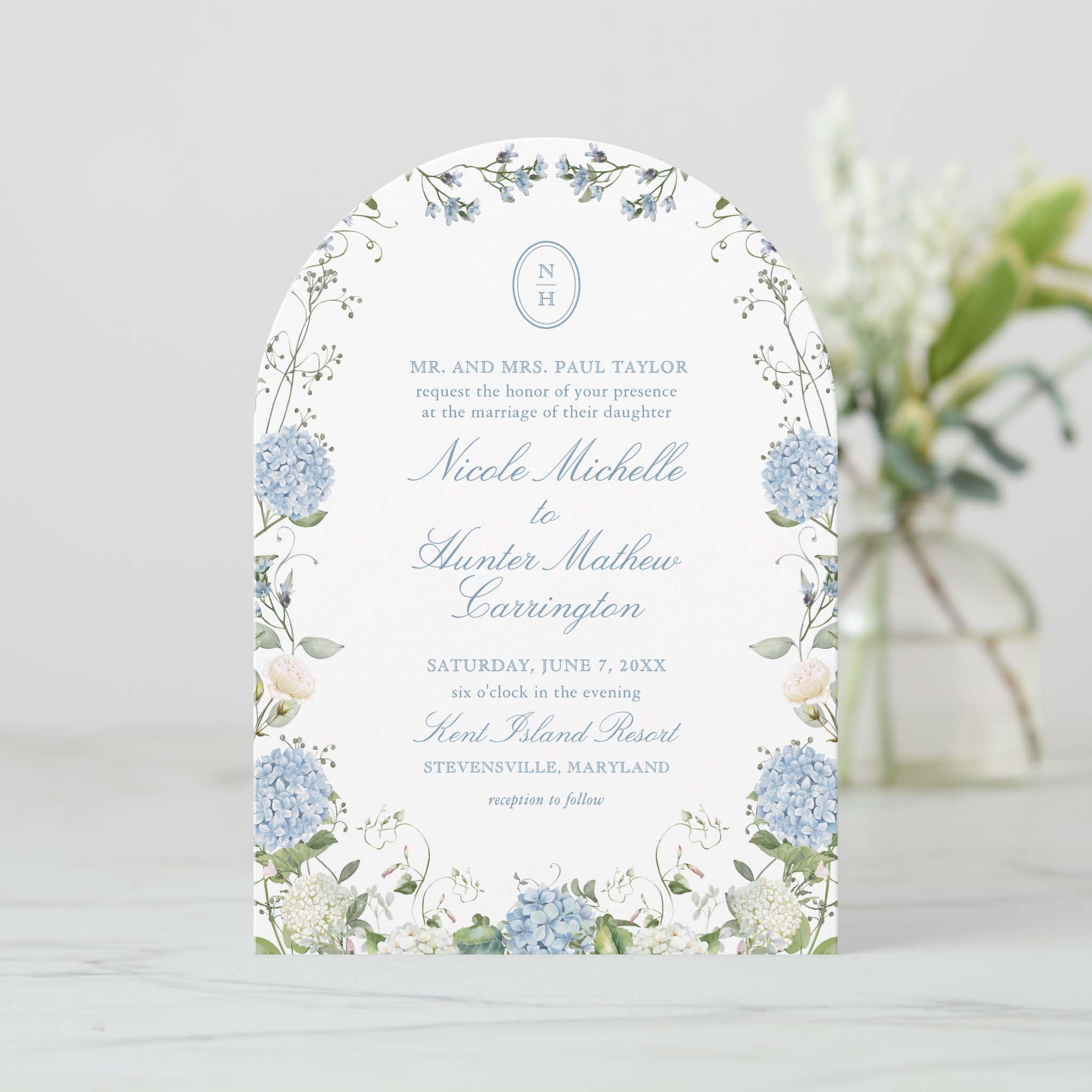 Arch shaped blue hydrangea garden border wedding invitation with soft greenery and monogram at the top.