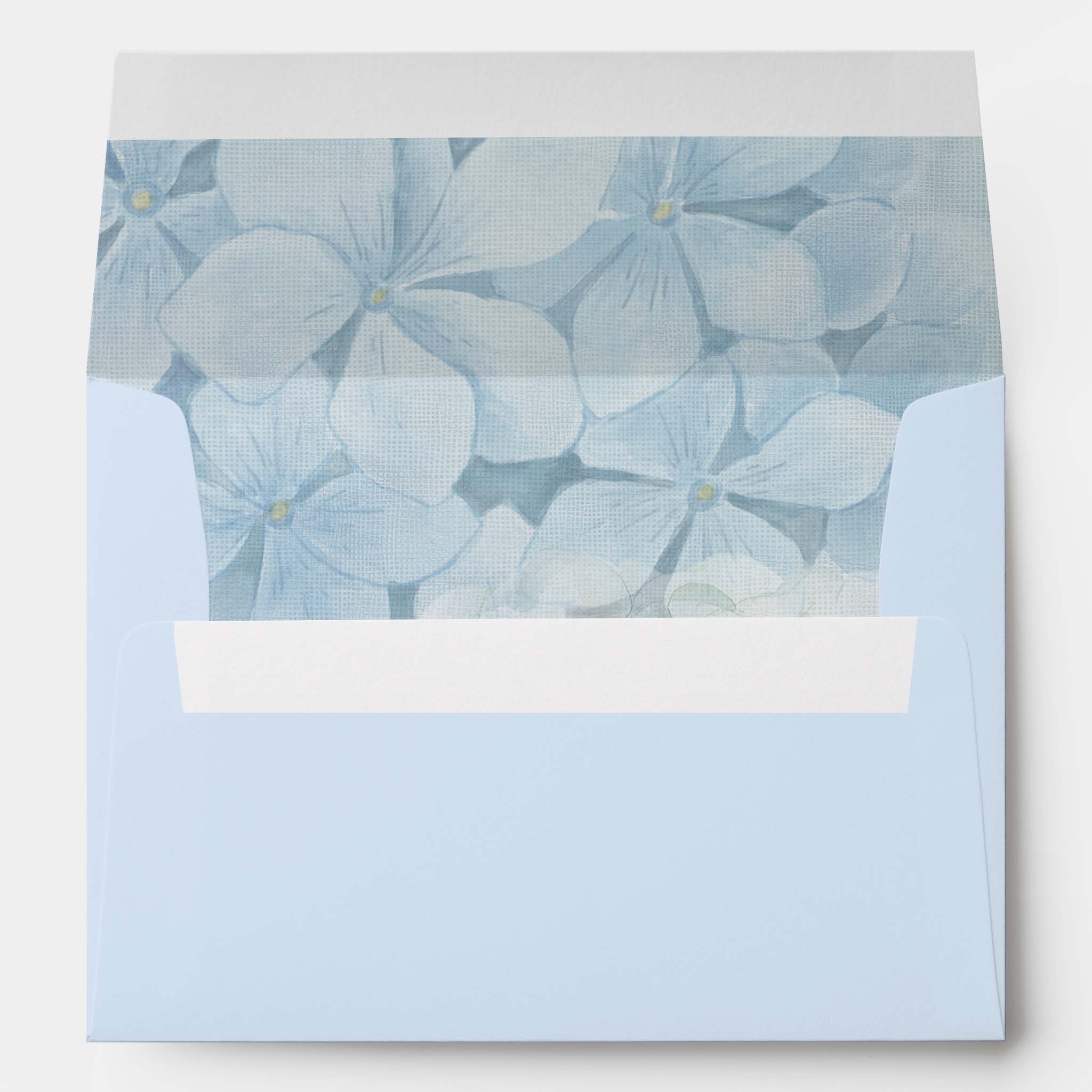 Light blue wedding invitation envelope with blue hydrangea floral liner coordinating with blue hydrangea wedding invitations.