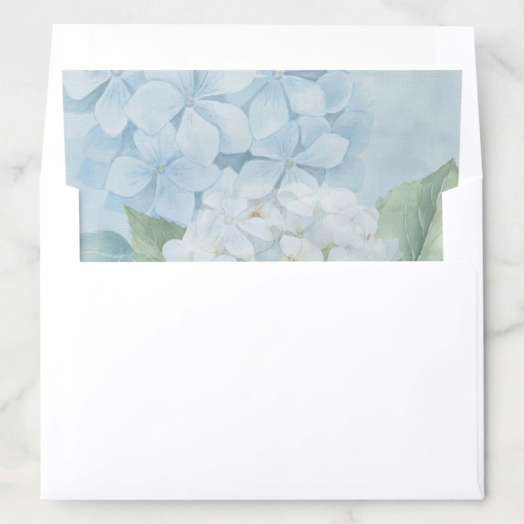 White wedding invitation envelope with blue hydrangea floral liner for blue hydrangea wedding invitations.